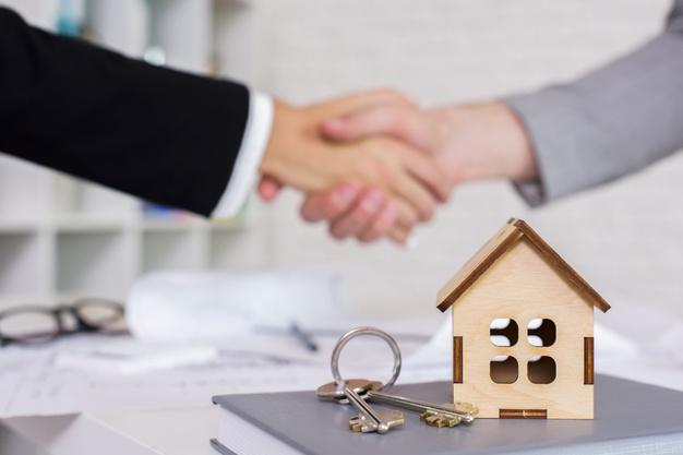 Representante inmobiliario y cliente cerrando un acuerdo de una venta de un piso mediante un apretón de manos