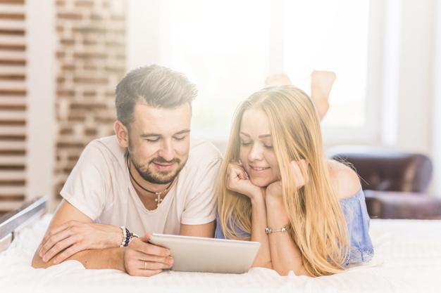Pareja matrimonial viendo en su tablet fotos de una casa que es de su agrado