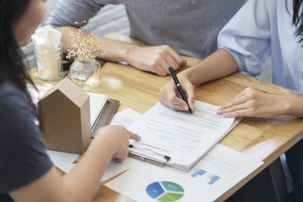 Cliente firmando un acuerdo con una inmobiliaria para alquilar un piso.
