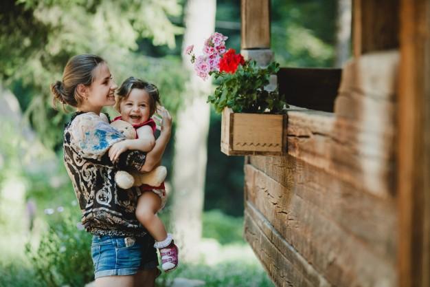 Chica con su hija disfrutando del jardín de su nueva casa
