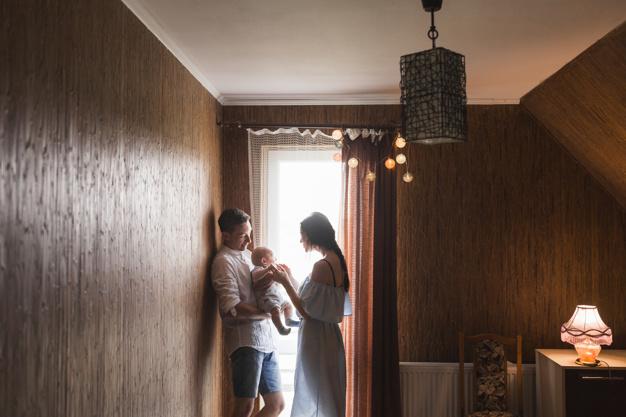 Pareja disfrutando en su nueva casa con su bebe recién nacido