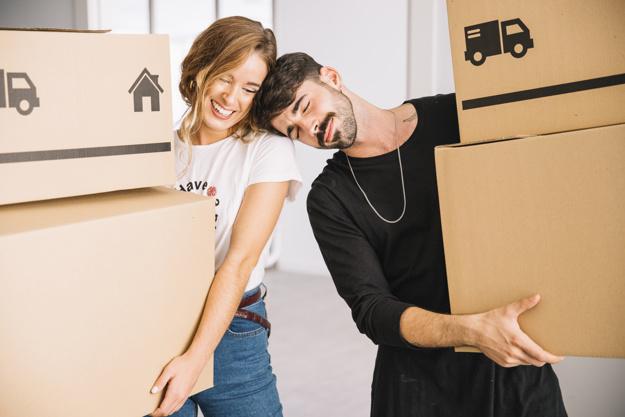 Pareja feliz mientras sostienen unas cajas para hacer la mudanza a su nueva vivienda