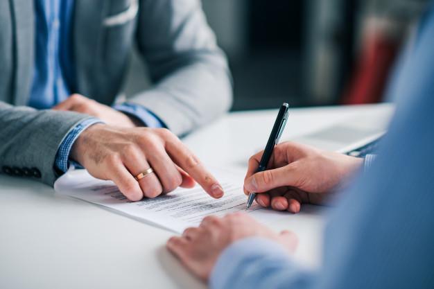 Representante Inmobiliarios explicando las obligaciones o condiciones en la venta de inmuebles al cliente en el momento de su firma