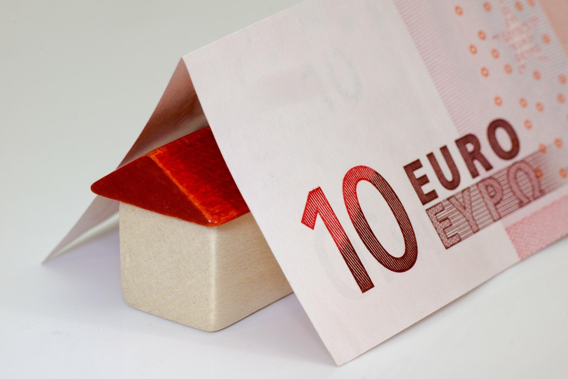 Billete de 10 euros sobre casa de color rojo y blanco