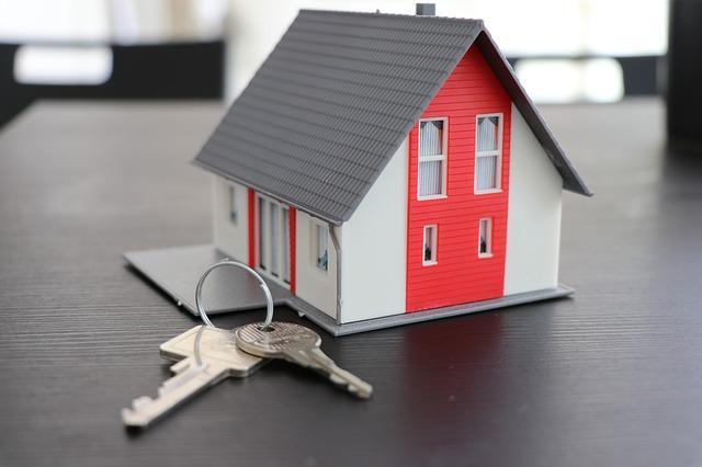 Casa en forma de maqueta mientras al lado se encuentran unas llaves de un nuevo hogar