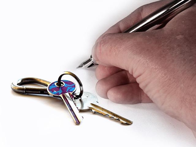 Persona escribiendo en un papel mientras al lado aparecen unas llaves