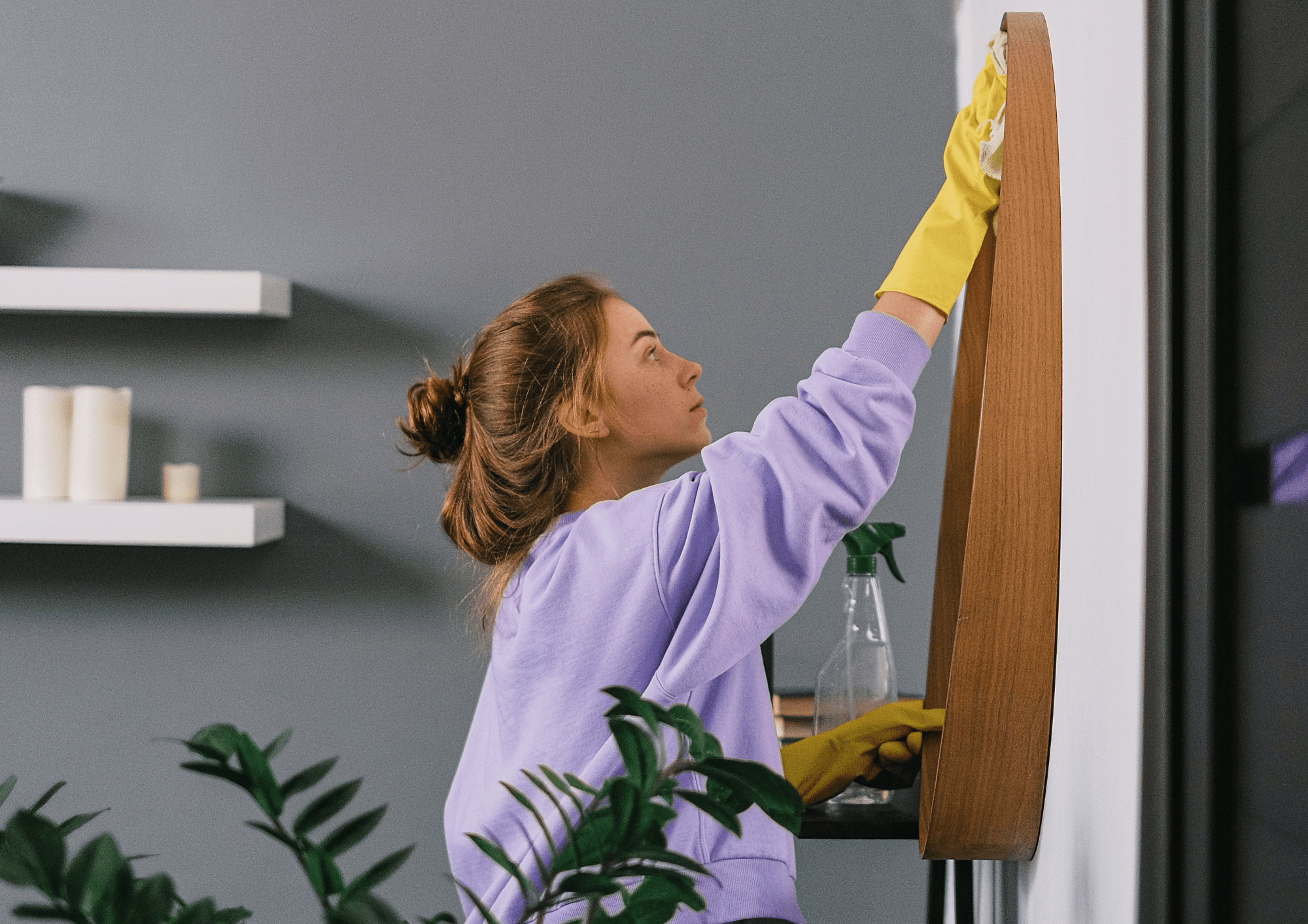 Mujer limpiando espejo de casa para la muestra de la misma