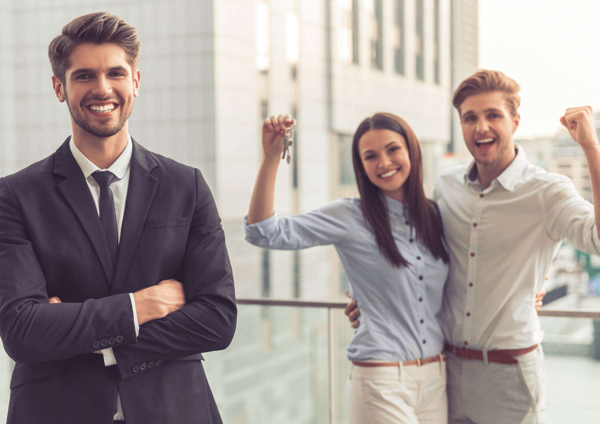 Agente inmobiliario de Fincamps alegrando a dos compradores