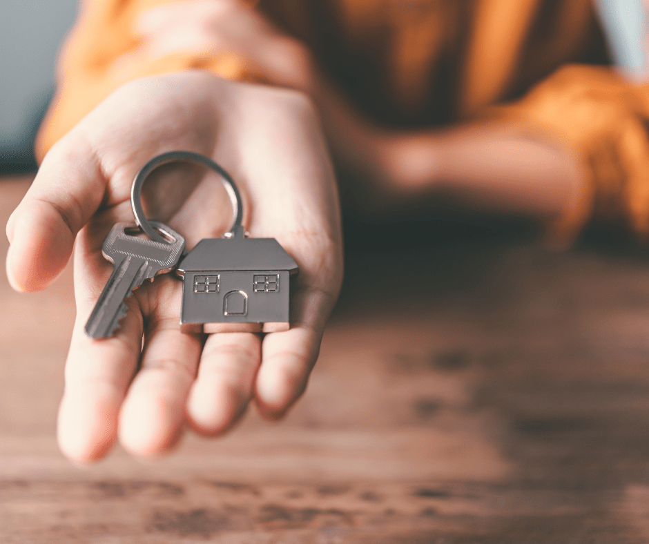 Manos sujetando llaves de una casa en venta