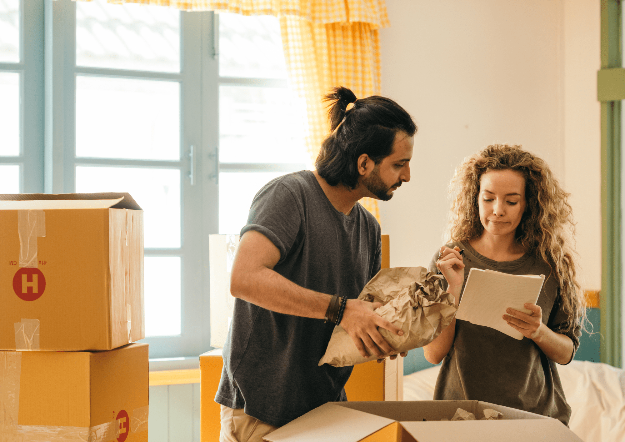 Pareja estableciendo el precio y reordenando los diferentes objetos de su casa