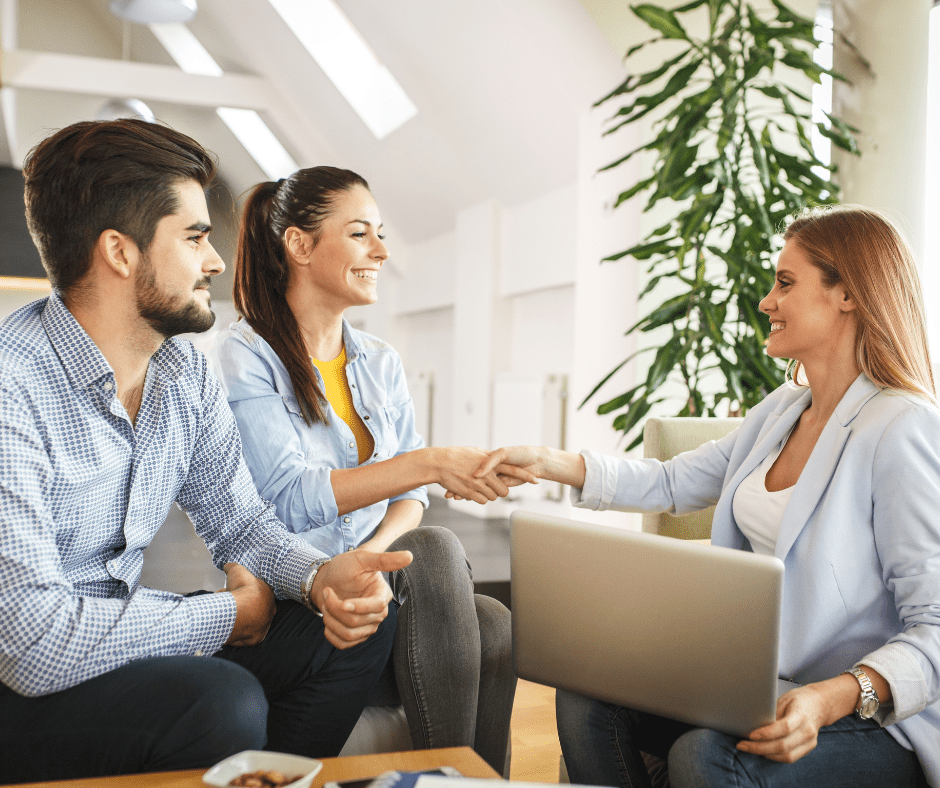 Pareja pactando con inmobiliaria la compra final de su nuevo hogar