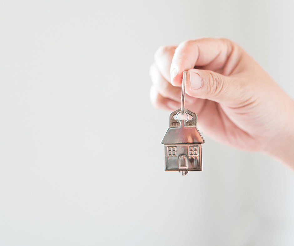 Persona sujetando un llavero con forma de casa