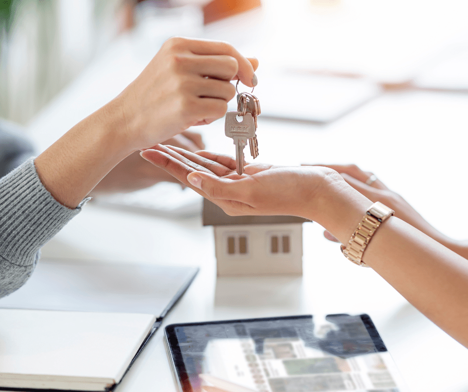 Representante inmobiliaria entregando las llaves de una nueva propiedad a una clienta