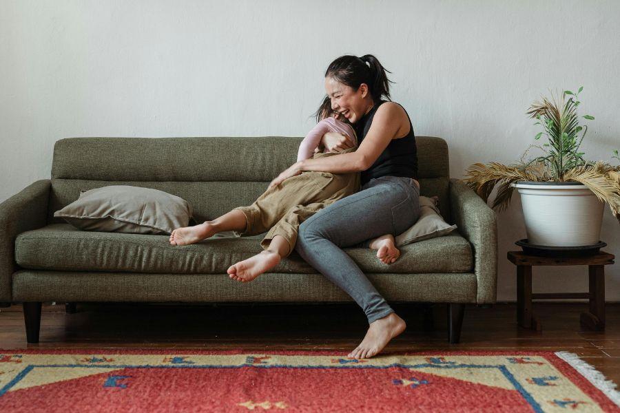 madre juega con su hijo en el sofá