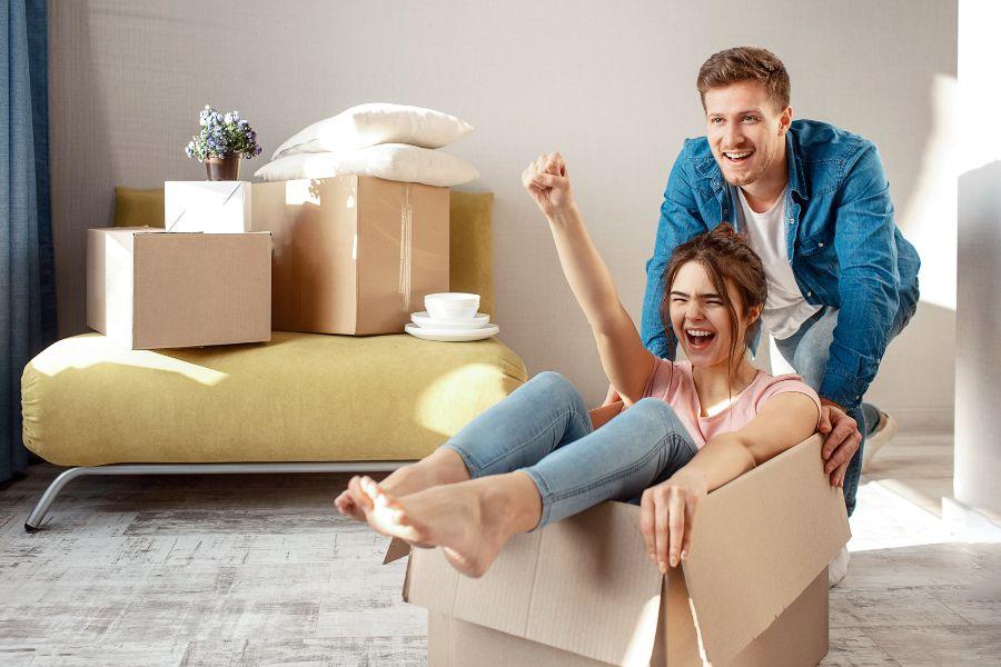 pareja contenta entre cajas de mudanza